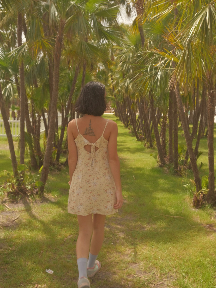 Woman walks through palm tree land at Ananda Farm